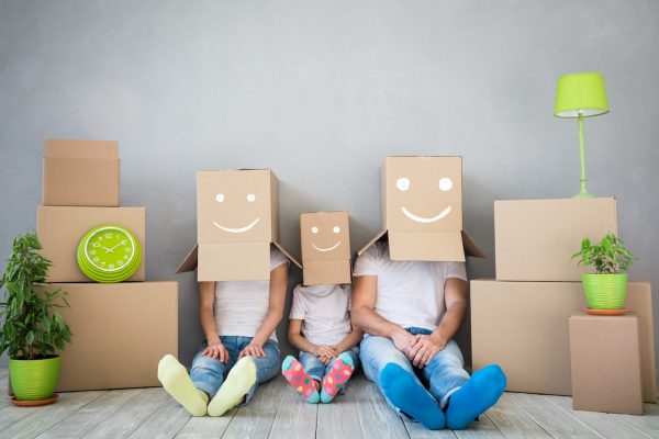 Happy family playing into new home. Father, mother and child having fun together. Moving house day and 
